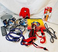 Wide view of all items including metal and plastic pet bowls, harnesses, leashes, sticky sheets, grooming tool, plush toy