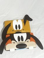 Two wallets featuring Disney characters Goofy and Pluto showing front faces with 3D ears detail.