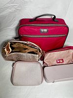 Burgundy Me To We lunch bag with four accessory bags displayed in front: gold glitter pouch, small pink pouch, beige pouch, light pink rectangular pouch.
