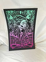 Front view of New Orleans inspired vintage print with bright blue and pink colors on black background, showing stylized female figure and text.
