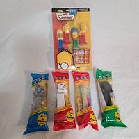 Photo of The Simpsons family PEZ dispenser set and four Star Wars PEZ dispensers all in original packaging