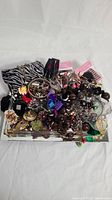 Full top-down view of the jewelry lot showing multiple items of varied colors and styles on a tray (tray not included).