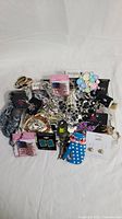 Wide view showing the full collection of assorted vintage and modern costume jewelry spread on a white background.