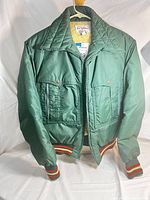 Front view of vintage green 1st Down jacket with dual snap button pockets and striped ribbed cuffs and waistband.