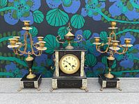 Full set showing clock and two candelabras against floral backdrop.