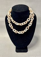 Full view of the double-layered pearl necklace displayed on black bust, showcasing overall length and pearl arrangement