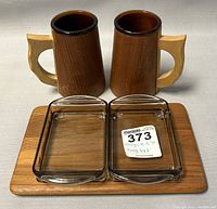Two teak-handled glass tankards, two rectangular clear glass bowls placed on a rectangular teak serving tray, neutral background.