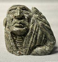 Front view showing detailed facial features and headdress of the soapstone carving.