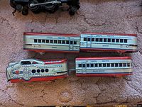 Four pieces of Marx M-10000 Union Pacific streamlined passenger electric train cars on carpet background.