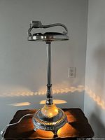 Full view of the ashtray stand illuminated and placed on wooden table