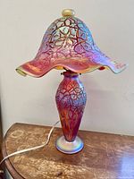 Unlit full view of lamp showing ruffled shade, base and power cord.