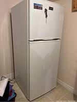 Closed view of white top-freezer refrigerator showing exterior condition