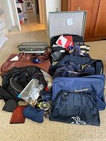 Photo showing a collection of assorted soft travel bags and accessories arranged on the floor.