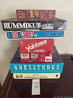 Stacked view of all board games included in the lot showing titles and packaging.