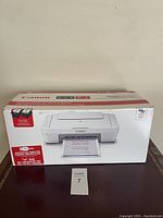 Photo of Canon PIXMA MG3020 printer box, front view with image of printer and product info.