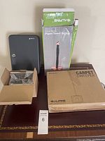 Photo showing Alpine carpet sweeper box, paper towel holder box, locking key box, and small box with keys.
