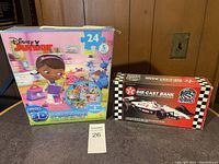 Shows the Disney Junior Super 3D Puzzle Pack and the Die-Cast Racing Edition coin bank in their original boxes.