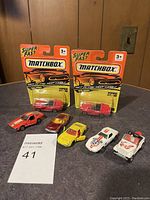 Matchbox cars lot featuring two red Viper cars sealed in original packaging and five loose diecast cars of various colors and features
