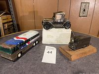 Overview photo showing all three vintage toy vehicles: bus, delivery van, and classic car model on box