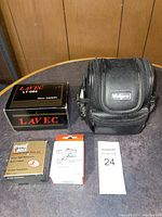 Photo showing the LAVEC LT-002 camera box, the black Vidpro camera case, Coastal Camera filter kit and Stromberg Carlson accessory box arranged on a table.