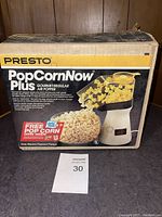 Front view of original box for Presto PopCornNow Plus air popcorn maker showing product image and branding.