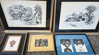 Six framed prints arranged on a surface against a brick wall. Two large black and white landscape sketches, one classical urn illustration, one colorful abstract print, and two black and white portraits with blue mats.