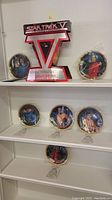 Six Star Trek V: The Final Frontier collectible plates arranged on shelves, displayed with their stands.