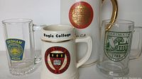 Front view of four mugs showing logos and details