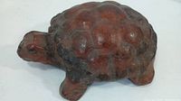 Side view of carved wooden turtle ornament showing detailed shell design