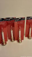 Four battery operated candle lamps still sealed in packaging, shows overall lot contents.