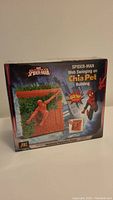 Box front image of sealed Spider-Man Chia Pet showing product design and branding.