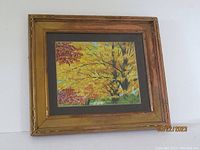 Entire framed watercolor painting in autumn theme with gilt frame showing some finish loss.