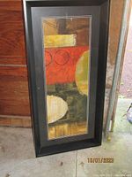 Framed abstract art print showing geometric shapes and colors in black frame