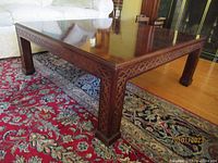 Front angle view of square Herendon Chinese Chippendale mahogany coffee table showing table top and carved apron detail