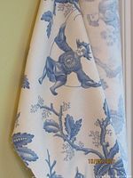 Close-up of designer blue and white fabric bolt with bird and foliage pattern