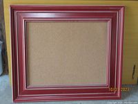 Full front view of the peg board showing red colonial style frame and natural peg board surface