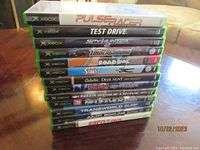 Stack of 13 Xbox video game cases showing spines with game titles.