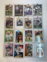 Front view of 16 NFL football player trading cards in protective sleeves, showing player images and various team jerseys.