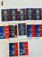 Assorted Hallmark American Spirit Collection Quarter Dollar packaging showing new old stock condition with multiple coins from different states.