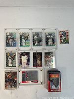 Lot of assorted collectible NFL and NBA trading cards displayed in protective plastic holders and a metal collector's tin box.