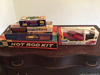 Photo of stacked boxes showing model car kits including Eldon Hot Rod Kit, Battery Operated Indianapolis Racer, and The Stinger Competition Dragster