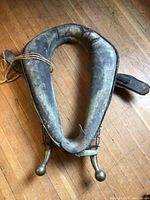 Top-down view of worn leather $ saddle highlighting overall shape and metal hardware ends