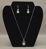Full view of necklace and earrings on black display stand showing design and size proportion of jewelry set.