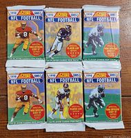 Six sealed packs of 1990 Score Series 2 NFL football cards, each pack containing 16 cards.