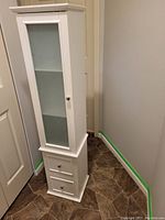 Closed cabinet showing frosted glass door on upper section, lower solid door and two drawers.