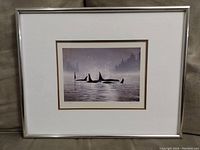 Full image of framed print showing metal frame and matting with orcas in misty bay scene.