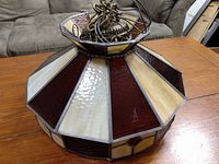 Side view showing alternating amber marbled and dark red stained glass panels framed with lead cames.