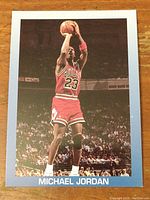 Front photo of 1990/91 Michael Jordan basketball card showing him in Chicago Bulls uniform jumping and shooting a basketball.