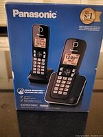 Original Panasonic product box showing image of black KX-TGC382C cordless phone set and model number