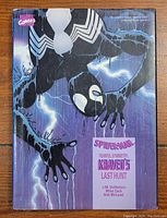 Cover of the hardcover book featuring Spider-Man in black suit with a rain and lightning background, that collects the complete 6-part Kraven saga.